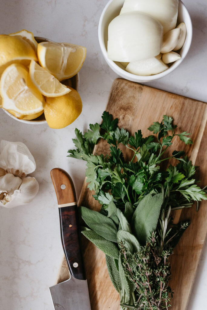 Photo of ingredients on a kitchen counter, along with cooking utensil like a cutting board and knife. Represents the concept of being present when you cook and romanticizing daily tasks for the sake of enjoyment.